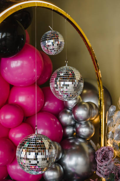 istock Luxury arch is decorated with disco balls. Golden wall for party time. Light blurred background for birthday. Photo zone with black, silver, pink, balloons, disco style, led strip. Detail closeup 1474834948