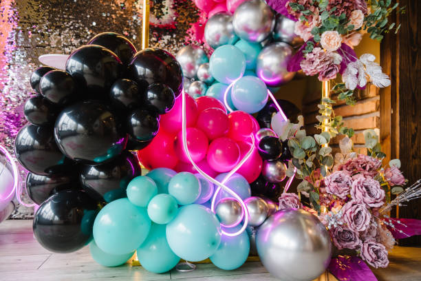 istock Luxury arch is decorated with flowers. Silver wall for party time. Light blurred background for birthday. Photo zone with black lights, silver, pink, blue balloons, disco style, led strip. Details. 1474834949