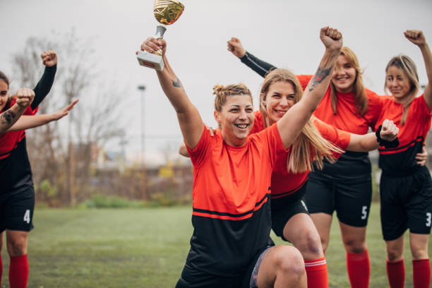 istock Female rugby team celebrating a trophy 1474835018