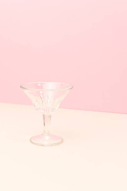 istock Small crystal glass in front of pink background. 1474835131