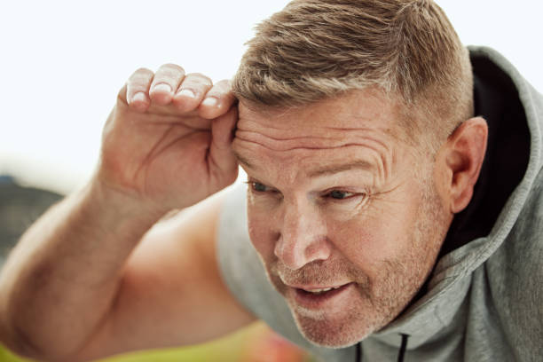 treino, exercício e homem idoso cansado, treinamento e fitness para o bem-estar, cardio e energia. homem maduro, atleta e exausto após a corrida, pausa e equilíbrio para um estilo de vida saudável, poder e descanso - senior adult human face male action - fotografias e filmes do acervo