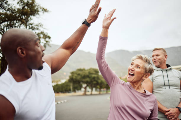 istock Fitness, high five and diversity friends or people with support, accountability and teamwork in nature training, exercise or workout. Wellness, community and senior with target, success or goal sign 1474837076