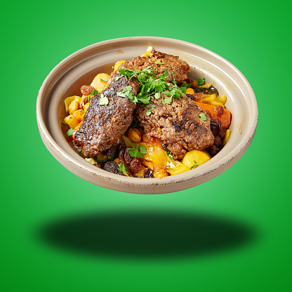 Floating  Morroccan Kofte Couscous on green gradient background