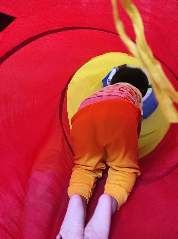Small toddler playing in a tunnel tube