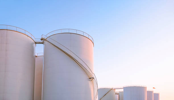 grupo de tanques de combustible de almacenamiento en el área de fabricación industrial petrolera contra un fondo de cielo despejado en horario nocturno - fuel storage tank storage tank oil storage compartment fotografías e imágenes de stock