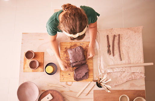 Pottery, creative and startup with a woman designer working in her studio for art from above. Manufacturing, small business and scupture with a female entrepreneur, employee or artist in a workshop