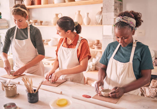 istock Pottery sculpting and people row at workshop together for creative process, production and productivity. Focus, concentration and talent of interracial team of women in artistic workspace. 1474840597