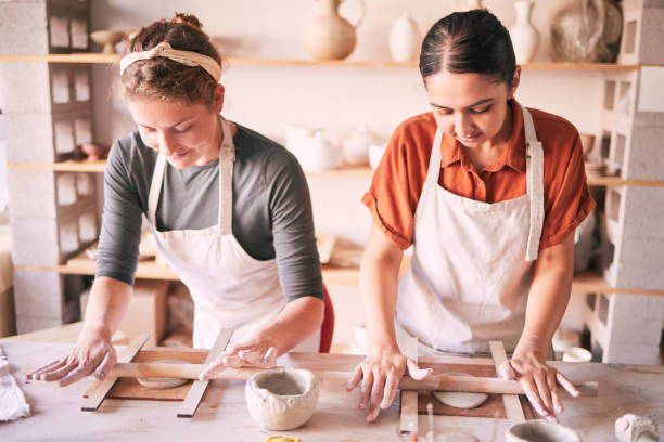 istock Pottery, design and small business people in workshop teamwork, collaboration and startup production. Clay, manufacturing and creative woman, artist or partner working together on sculpture process 1474840859