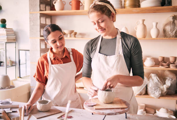 istock Pottery class, workshop or women teaching sculpture design, clay manufacturing or art product. Creative mold, ceramic retail store and startup small business owner, artist or people working in studio 1474841033