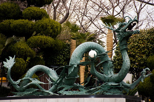 Ancient antique art dragon statue in garden for korean people and foreign travelers use eat drinks in Diamond Busan Tower and Yongdusan public park in Nampo dong at Jung gu city in Busan, South Korea