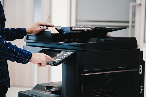 Copier printer, Close up hand office man press copy button on panel to using the copier or photocopier machine for scanning document printing a sheet paper.