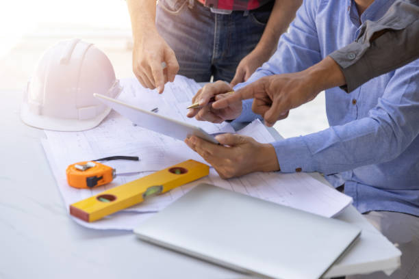 istock Construction concept of Engineer and Architect working at Construction Site with blue print, Engineer and Architect discussing construction plan with computer laptop calculator 1474845824
