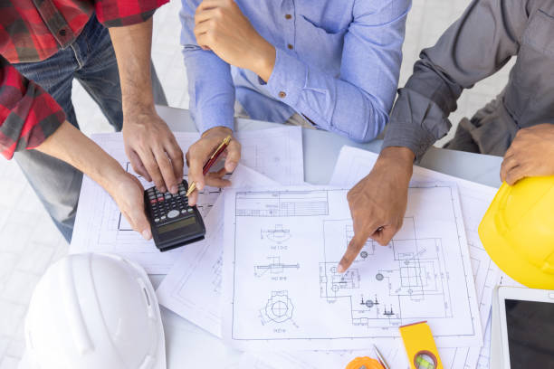 istock Construction concept of Engineer and Architect working at Construction Site with blue print, Engineer and Architect discussing construction plan with computer laptop calculator 1474845839