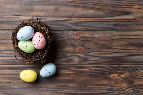 istock Colorful easter eggs in nest on table background with copy space top view 1474846022