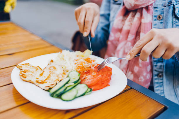 istock A woman eats chicken and salad in a restaurant 1474847298