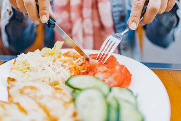 istock A woman eats chicken and salad in a restaurant 1474847310