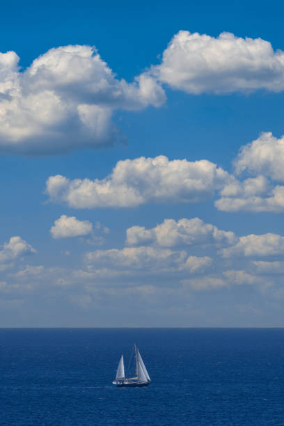 istock Sailboat on blue sky and white clouds 1474847356