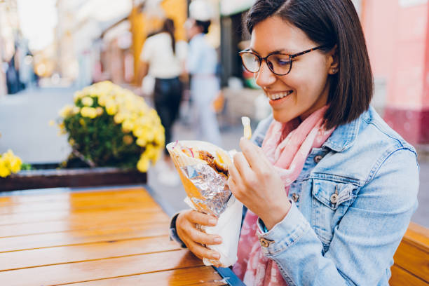istock Young woman eating gyros 1474848107