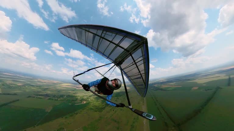 Girl hang glider pilot flies in the air with other pilots