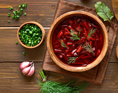 Beetroot soup, borscht in bowl on wooden background. Top view, flat lay