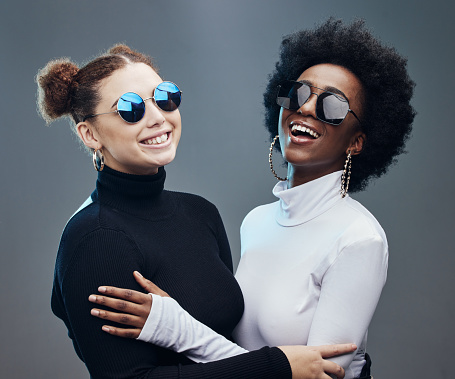 Fashion, futuristic and women smile in sunglasses, cyberpunk and trendy designer brand with gen z youth. Marketing, diversity and contemporary style with vision and edgy against studio background