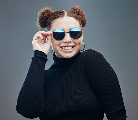 Fashion, smile and woman with sunglasses for beauty cosmetics, makeup and luxury style in studio. Fashion model, designer brand and confident girl with stylish accessories, trendy and edgy jewellery