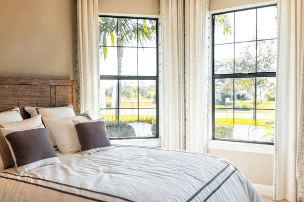 Made bed with decorative pillows in bedroom of home house in elegant decor with bright bay window during sunny day in tropical Florida climate with view Made bed with decorative pillows in bedroom of home house in elegant decor with bright bay window during sunny day in tropical Florida climate with view florida real estate house home interior stock pictures, royalty-free photos & images