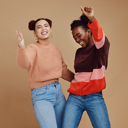 Happy, teenager and girl with dance and friends, young and trendy with gen z style, fun and freedom against studio background. Laughing, funny and dancing with stylish youth, energy and marketing