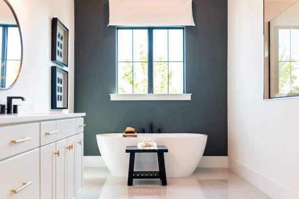 vasca da bagno in bagno modello casa casa o hotel con moderni armadi bianchi di lusso interni, finestra con luce e specchi - bagni foto e immagini stock