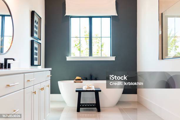 Bathtub In Bathroom Staging Model Home House Or Hotel With Modern Luxury White Cabinets Interior Window With Light And Mirrors Stock Photo - Download Image Now