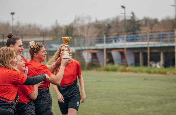 istock Female rugby team celebrating a trophy 1474853067
