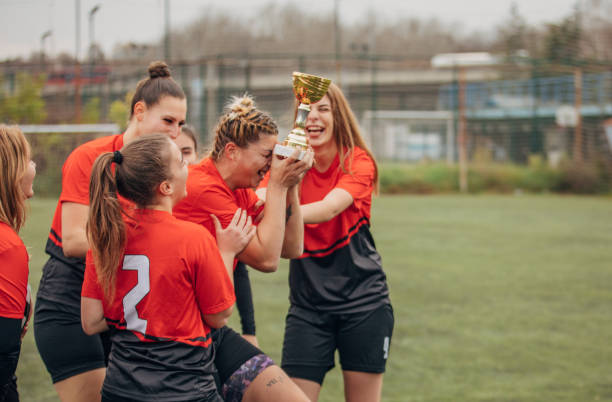istock Female rugby team celebrating a trophy 1474853119
