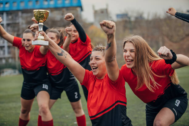 istock Female rugby team celebrating a trophy 1474853313