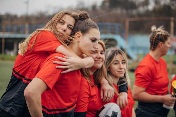 istock Female rugby team celebrating a trophy 1474853864