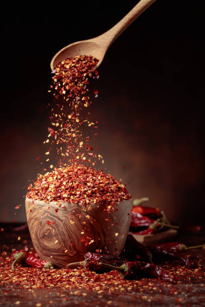 istock Chilli flakes are poured into a wooden dish. 1474854758