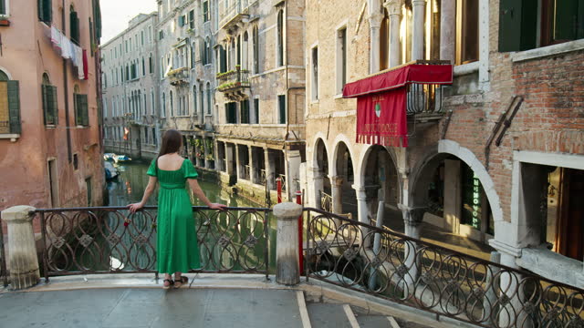 A young girl looking over the bridge by the grand canal in Venice, Italy.