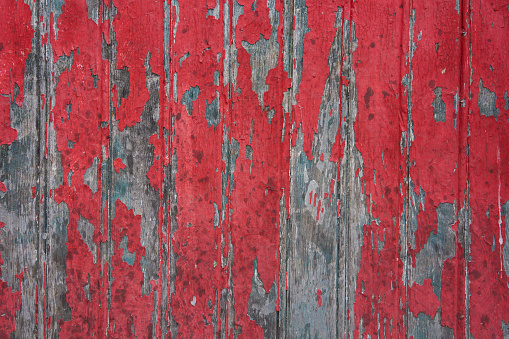 Сracked paint on wood vintage texture. Painted old wooden red wall background. Weathered wooden grunge background.
