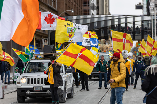 Toronto, Canada - March 19, 2023 : A group marching with County Antrim flags at the Saint Patrick's Day parade