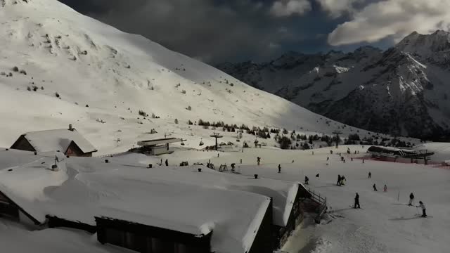 Aerial video of people snowboarding and skiing in South Tyrol