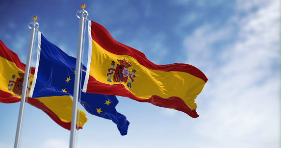 the flags of Spain and the European Union waving in the wind on a sunny day. Democracy and politics. European country. 3d illustration render. Rippled textile