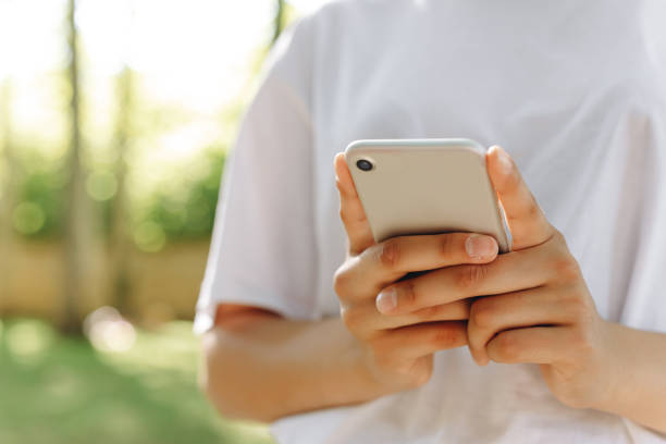 istock A beautiful female is walking and doing something with a phone. 1474861132