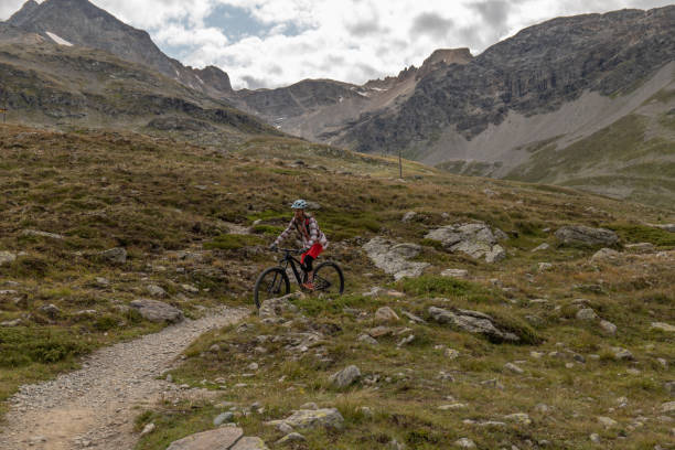 istock Young woman mountain bikes along mountain trail 1474862421