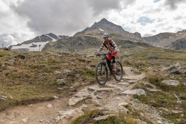 istock Young woman mountain bikes along mountain trail 1474862678