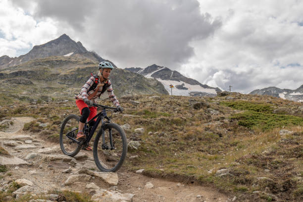 istock Young woman mountain bikes along mountain trail 1474862889