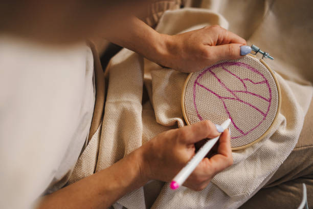 крупный план руки женщины рисуют карандашом на холсте контур того, что она хочет вышить. женское увлечение вышивкой. вышивка крестиком. - embroidery embroider wool thread стоковые фото и изображения