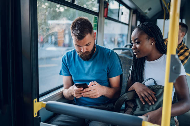istock Multiracial friends talking and using a smartphone while riding a bus in the city 1474864615