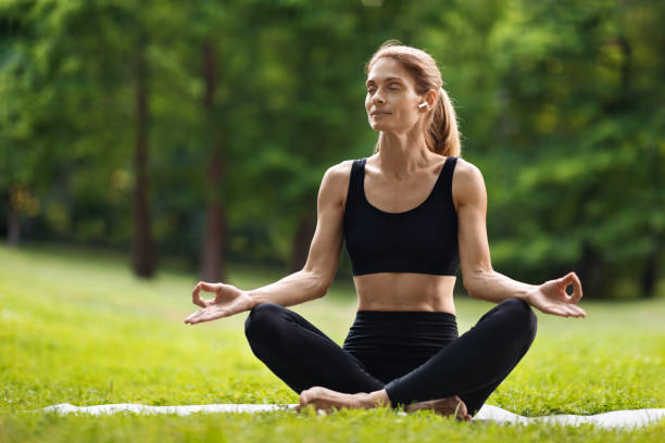 istock Peaceful blonde woman practicing yoga at public park, copy space 1474864985