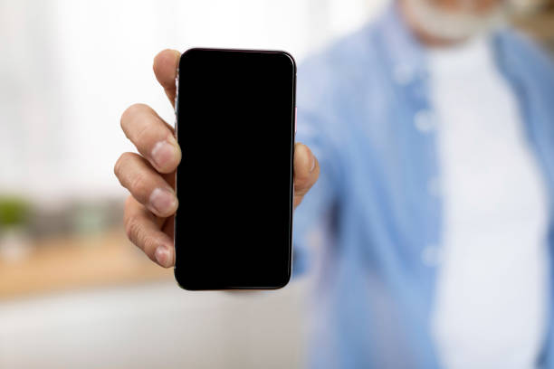 istock Unrecognizable Senior Man Holding Modern Smartphone With Big Blank Screen 1474865008