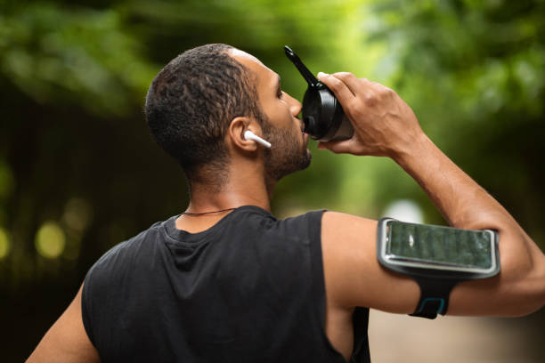 istock Athletic african american man drinking water, exercising at park 1474865069