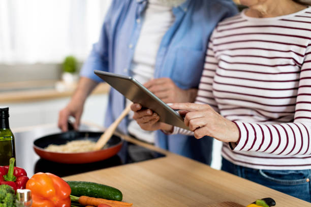 istock Senior Couple Using Digital Tablet In Kitchen While Cooking Food 1474866906
